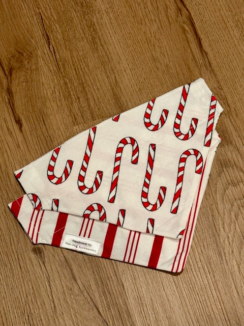 candy cane pattern bandana with red and white stripes on the back on a wooden surface