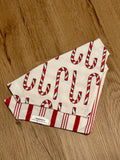 candy cane pattern bandana with red and white stripes on the back on a wooden surface