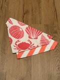 red seashells print on one side, coral cabana stripes on the other