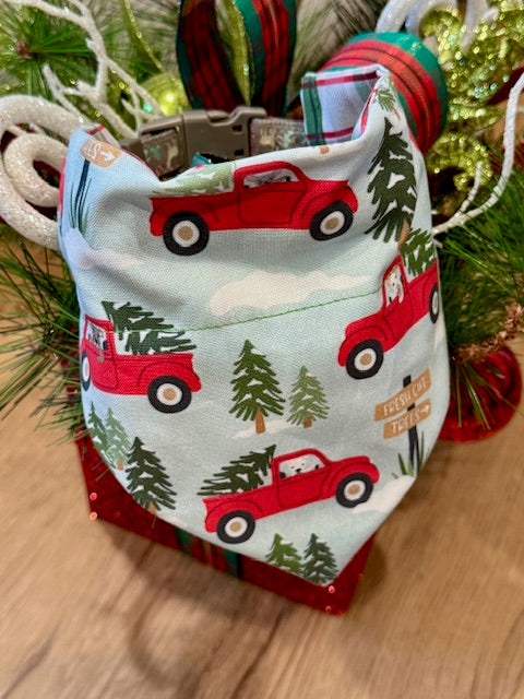 red truck and Christmas tree pattern bandana on a wooden surface with decorative christmas background