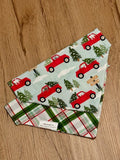 Two fabric swatches with Christmas truck and tree patterns on a wooden surface