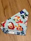 Dog bandana with festive dog designs on a wooden surface