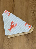 dog bandana with red lobster design on a wooden surface